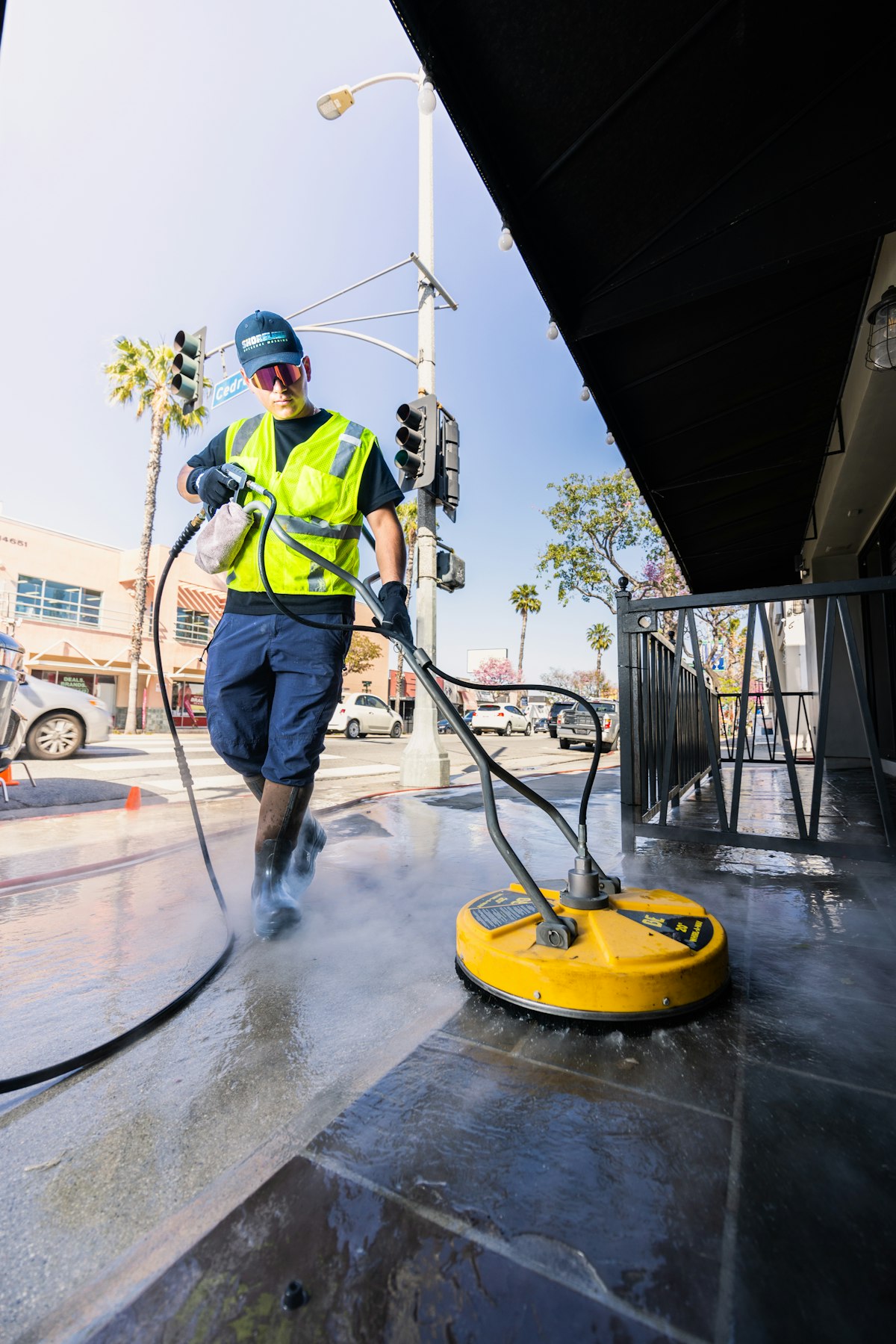 Pressure washing professional on a job site wearing a custom hat