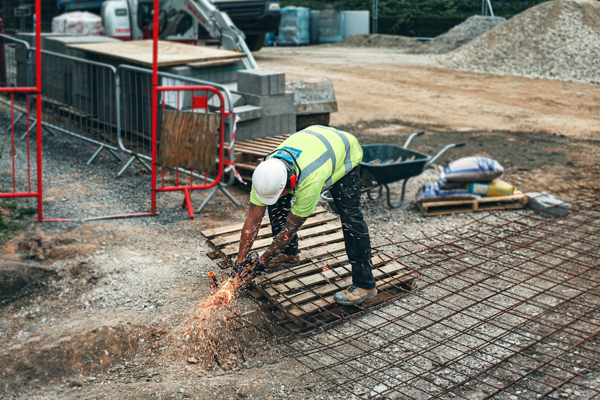Concrete finishing crew wearing matching branded hats while finishing a slab